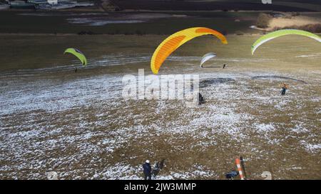 Gleitschirmfliegen und Bodenabfertigungstraining auf der Wiese von Bykovice, Tschechien, Europäische union, Luftpanorama-Aufnahme mit DJI-Drohne im Winter Stockfoto