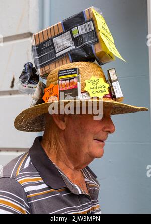 Bridport, Dorset, Großbritannien. 3.. September 2022. Eine Vielzahl von Stil und schrulligen Hüten, die von Menschen und Hunden beim Bridport hat Festival in Dorset hergestellt und getragen werden. Der Mann trägt den Lebenshaltungskosten-Krisenhut und vergleicht den Preis von Broten mit Zigarettenschachteln. Quelle: Carolyn Jenkins/Alamy Live News Stockfoto