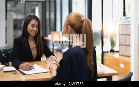 real estate agent holding house key to his client after signing contract,concept for real estate, moving home or renting property Stock Photo