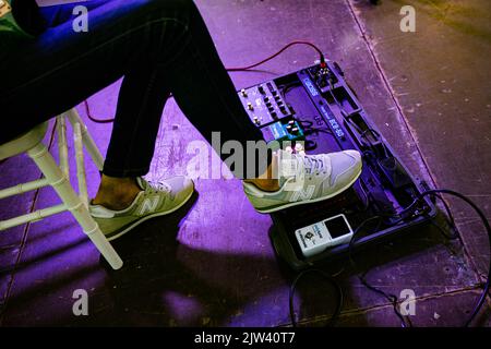 Lviv, Ukraine - Mai, 2021: Foot Wearing New Balance Sneaker drücken auf Effekteinheiten für Gitarre auf der Konzertbühne Stockfoto