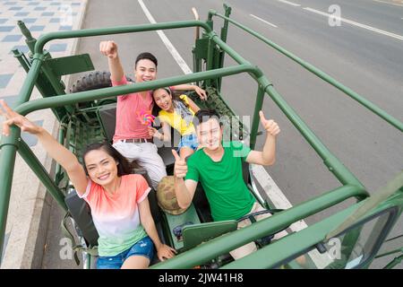 Eine Gruppe glücklicher junger Menschen, die mit dem Jeep reisen Stockfoto