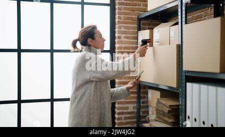 Mittelalter hispanische Frau E-Commerce-Business-Arbeitnehmer Scannen Paket mit Barcode-Leser im Lagerhaus Büro Stockfoto