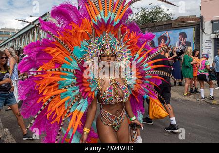 London, England, Großbritannien - 29. August 2022: Junge Leute, die für den Karneval mit Federn in verschiedenen Farben auf den Straßen in Notting Hill gekleidet sind Stockfoto