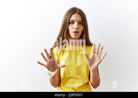 Junge Brünette Teenager stehen zusammen über isolierten Hintergrund weg Hände Handflächen zeigen Ablehnung und Ablehnung mit Angst und ekelhaft expre Stockfoto