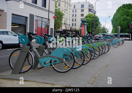 Paris, Frankreich - 29. Mai 2022: Reihe von Velib Elektrofahrrädern zum öffentlichen Mieten und teilen geparkt am Bahnhof Velib in der Straße auf der Ile de la Jatte Stockfoto