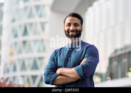 Selbstbewusster, glücklicher indischer Geschäftsmann, der im Freien ein Headshot-Portrait der Kamera ansieht. Stockfoto