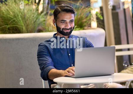 Indischer Geschäftsmann mit virtuellen Meeting-Videoanruf im nächtlichen Stadtpark. Stockfoto