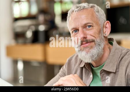 Ein glücklicher, älterer, grauhaariger bärtiger Mann aus nächster Nähe, ein Kopfschuss-Porträt. Stockfoto