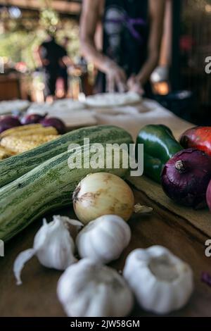 Knoblauch, rote Zwiebel, grüne Paprika, rote Paprika, Zwiebel, Mais und anderes Gemüse auf dem Tisch. Zubereitung von veganen Lebensmitteln. Gesund Stockfoto