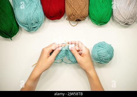 Frau Hände Strickmütze mit Nadeln und Garn. Stockfoto