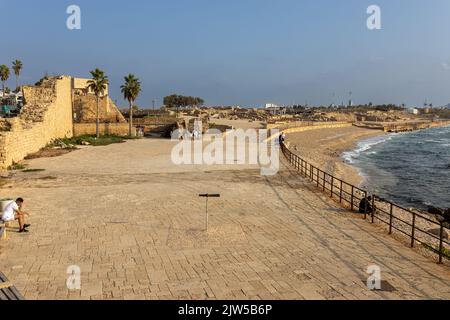 CAESAREA, Israel - 11 2022. August: Touristen im alten Hafen von Caesarea. Die alte Stadt und der Hafen von Caesarea Maritima wurden von Herodes dem Großen erbaut Stockfoto