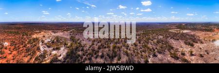 Opal-Minenschächte auf roten Bodenebenen um die Regionalstadt Lightning Ridge in NSW von Australien - Luftpanorama. Stockfoto