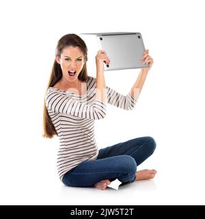 Mein Laptop stürzt immer wieder ab. Studio-Porträt einer jungen Frau mit einem Laptop vor weißem Hintergrund. Stockfoto