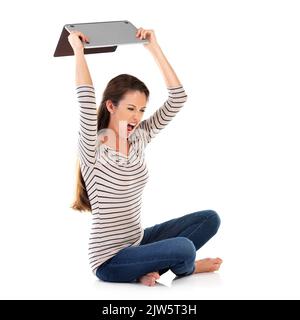 Ich bin so frustriert darüber. Studioaufnahme einer jungen Frau mit einem Laptop vor weißem Hintergrund. Stockfoto