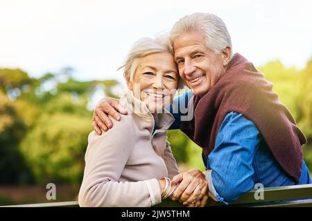 Erinnert euch daran, worum es bei Liebe geht. Porträt eines glücklichen älteren Paares, das auf einer Parkbank sitzt. Stockfoto