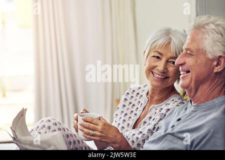 Paare, die zusammen lachen, bleiben zusammen. Ein Seniorenpaar liegt im Bett. Stockfoto