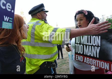 London, Großbritannien, 3.. September 2022. Ein Polizeibeamter steht zwischen der Aktivistin Patsy Stevenson und einem Pro-Life-Protestanten, während sie miteinander debattieren. Frauen-Pro-Choice-Aktivisten versammelten sich auf dem Parliament Square in einem Gegen-Protest gegen die jährliche March for Life-Veranstaltung, an der unter anderem evangelische Christen und Katholiken teilnahmen, die Abtreibung ablehnen und glauben, dass das Leben von der Empfängnis an beginnt. Wahlkampfgruppen sagen, dass der Umbruch von Roe gegen Wade die Anti-Abtreibungsgegner ermutigt hat. Kredit: Elfte Stunde Fotografie/Alamy Live Nachrichten. Stockfoto