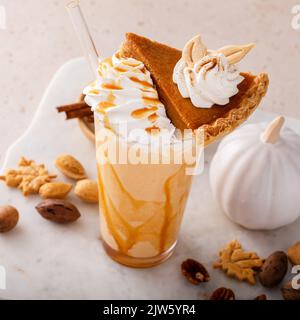 Kürbiskuchen-Milchshake mit Karamellsirup und Schlagsahne Stockfoto
