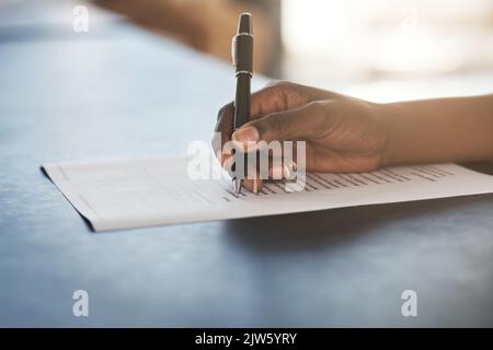 Korrektur des Vertrags. Die Aufnahme einer nicht erkennbaren Geschäftsfrau, die in ihrem Büro einige Schreibarbeiten ausfüllte. Stockfoto