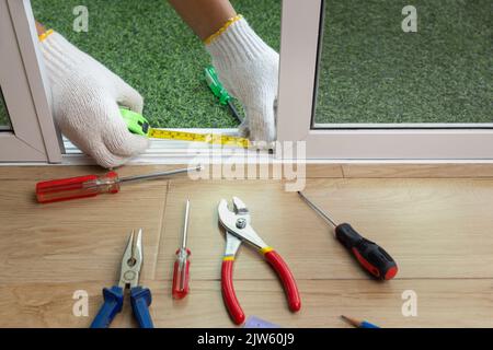 Arbeiter, der die Schiebetür des Insektenschutzschirms fixiert Stockfoto