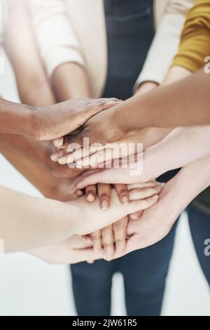 Der Geist der Teamarbeit. Eine Gruppe von Menschen, die ihre Hände zusammenlegen. Stockfoto