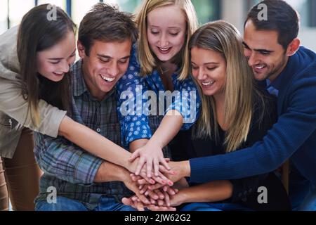 Huddle um das Team. Eine Gruppe von Leuten, die ihre Hände zusammenlegen. Stockfoto