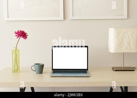 Laptop-Computer auf dem Schreibtisch mit weißem Bildschirm Stockfoto