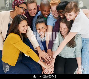 Alle Hände an Deck. Eine Gruppe von Menschen, die ihre Hände zusammenlegen. Stockfoto