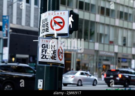 Am 3. September 2022 in New York City, USA, laufen die Menschen an einem Schild mit der Aufschrift „Gun Free Zone“ in der Nähe des Bryant Parks an einem der Zugangspunkte zum Times Square vorbei. Angesichts des jüngsten Urteils des Obersten Gerichtshofs der USA ist der Staat New York nun ein „soll-Issue“-Staat, der vorschreibt, dass jedem, der alle vorgeschriebenen Anforderungen erfüllt, keine offene oder stornierte Erlaubnis zum Tragen von Waffen verweigert werden kann. Allerdings hat der Staat New York Teile des Gesetzes geändert, in dem bestimmte Stadtteile als „Gun Free Zones“ (Foto: John Lamparski/SIPA USA) festgelegt wurden. Quelle: SIPA USA/Alamy Live News Stockfoto