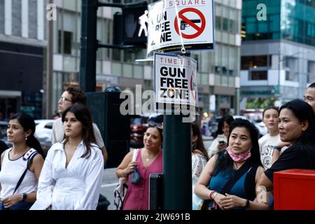 Am 3. September 2022 in New York City, USA, laufen die Menschen an einem Schild mit der Aufschrift „Gun Free Zone“ in der Nähe des Bryant Parks an einem der Zugangspunkte zum Times Square vorbei. Angesichts des jüngsten Urteils des Obersten Gerichtshofs der USA ist der Staat New York nun ein „soll-Issue“-Staat, der vorschreibt, dass jedem, der alle vorgeschriebenen Anforderungen erfüllt, keine offene oder stornierte Erlaubnis zum Tragen von Waffen verweigert werden kann. Allerdings hat der Staat New York Teile des Gesetzes geändert, in dem bestimmte Stadtteile als „Gun Free Zones“ (Foto: John Lamparski/SIPA USA) festgelegt wurden. Quelle: SIPA USA/Alamy Live News Stockfoto