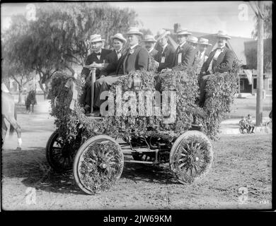 Eine Gruppe von Männern sitzt in einem dekorierten Auto für die Pasadena Tournament of Roses Parade - ca. 1903 Stockfoto