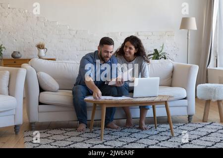 Meine Frau und ihr Mann zahlen Rechnungen, und sie sind zufrieden, wenn sie ihre Papiere aussortieren Stockfoto