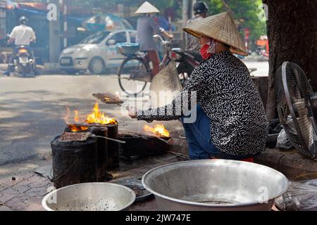 Vietnamesische Dame mit Bambushut, die auf der Straße kocht, Hai Phong, Vietnam Stockfoto