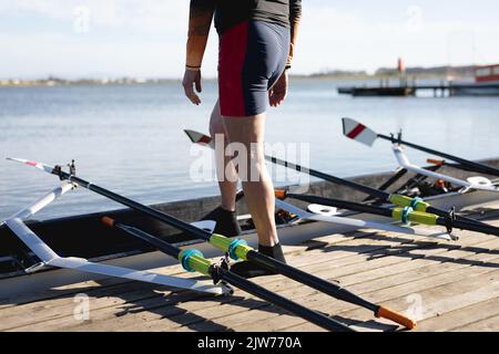 Niedriger Abschnitt eines älteren kaukasischen männlichen Ruderers, der auf dem hölzernen Dock steht Stockfoto