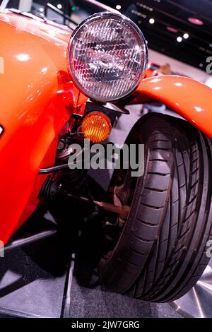 Klassische orangefarbene Sportwagen-Vorderräder und Scheinwerfer auf der Motorshow Stockfoto