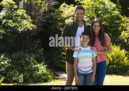 Porträt einer kaukasischen Familie, die gemeinsam Zeit in ihrem Garten verbringt Stockfoto