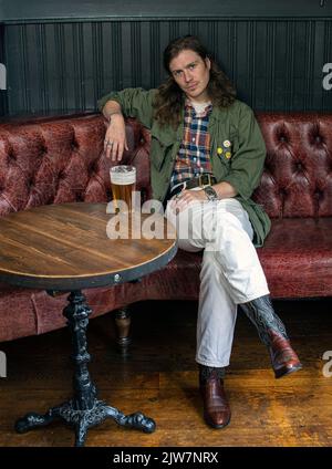 Der trendige Soho-Mann genießt ein Pint Bier im Dog and Duck Pub in London, Großbritannien. Stockfoto