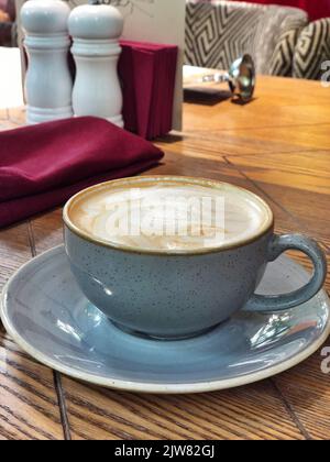 Keramikbecher aromatischen Kaffees mit Schaum auf Holztisch im Café Stockfoto