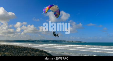 Beobachten Sie, wie ein Motorsegler die Thermik über den Dünen von Gwithian Sands Beach nutzt. Hayle Cornwall. Stockfoto