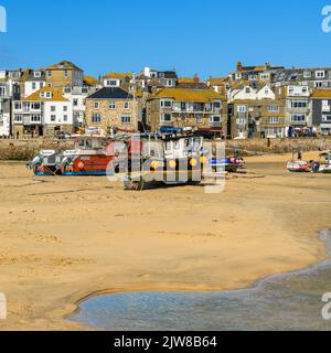 Ebbe am Hafen von St Ives, der sich in Ruhe um die Fischerboote schunkert und auf die Rückkehr der Flut wartet. Stockfoto