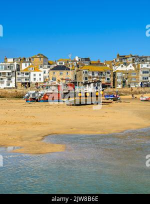 Ebbe am Hafen von St Ives, der sich in Ruhe um die Fischerboote schunkert und auf die Rückkehr der Flut wartet. Stockfoto