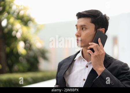 Hübscher asiatischer Geschäftsmann ruft auf dem Smartphone. Nahaufnahme. Stockfoto