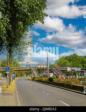 Köln (Deutzer Freiheit), Deutschland - Juli 9. 2022: Straße im Stadtzentrum, U-Bahn-Station, Zug, Triangle Tower, Fußgängerübergangsbrücke, Blaue Summe Stockfoto