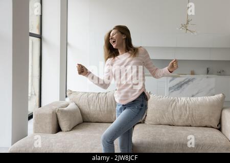Glücklich aufgeregt hübsche junge Frau, die Spaß zu Hause hat Stockfoto