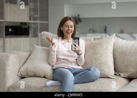 Fröhliche, glückliche Frau, die auf dem Mobiltelefon über einen Videoanruf spricht Stockfoto