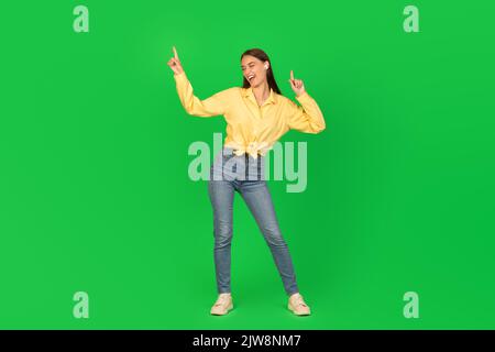 Fröhliche Frau Tanzt Musik Über Grünem Hintergrund Zuhören Stockfoto