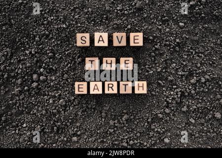 Schwarzer Boden Hintergrund Erde Tag. Brief Block Spielzeug Würfel Holz Text Speichern Sie die Erde Wortblock Holzwürfel Konzept Welt Umwelt Tag. Erde Stockfoto