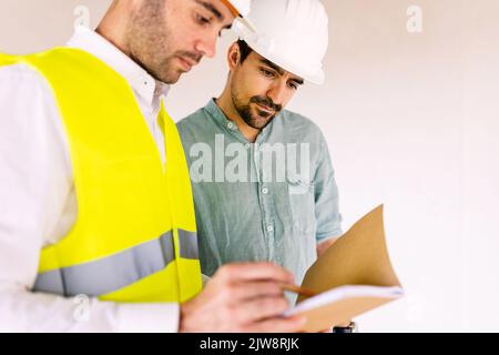 Architektin, der auf der Baustelle mit dem Auftragnehmer männlich diskutiert Stockfoto