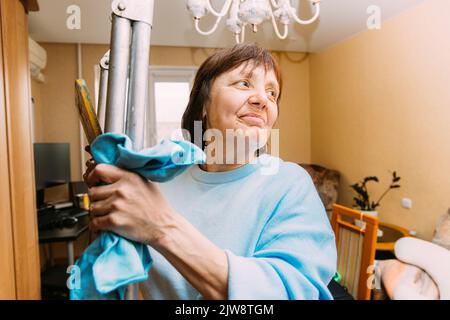 Glücklich Schüchtern Reifen Frau Reinigung Wohnung. Konzept Von Haushalt Und Menschen Im Ruhestand. Ältere Frau Reinigung Apartment. Konzept Für Aktive Senioren Stockfoto