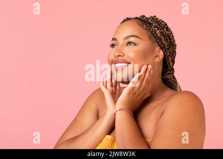 African Lady Touching Face Pflege Der Haut Zur Seite Schauen, Studio Stockfoto